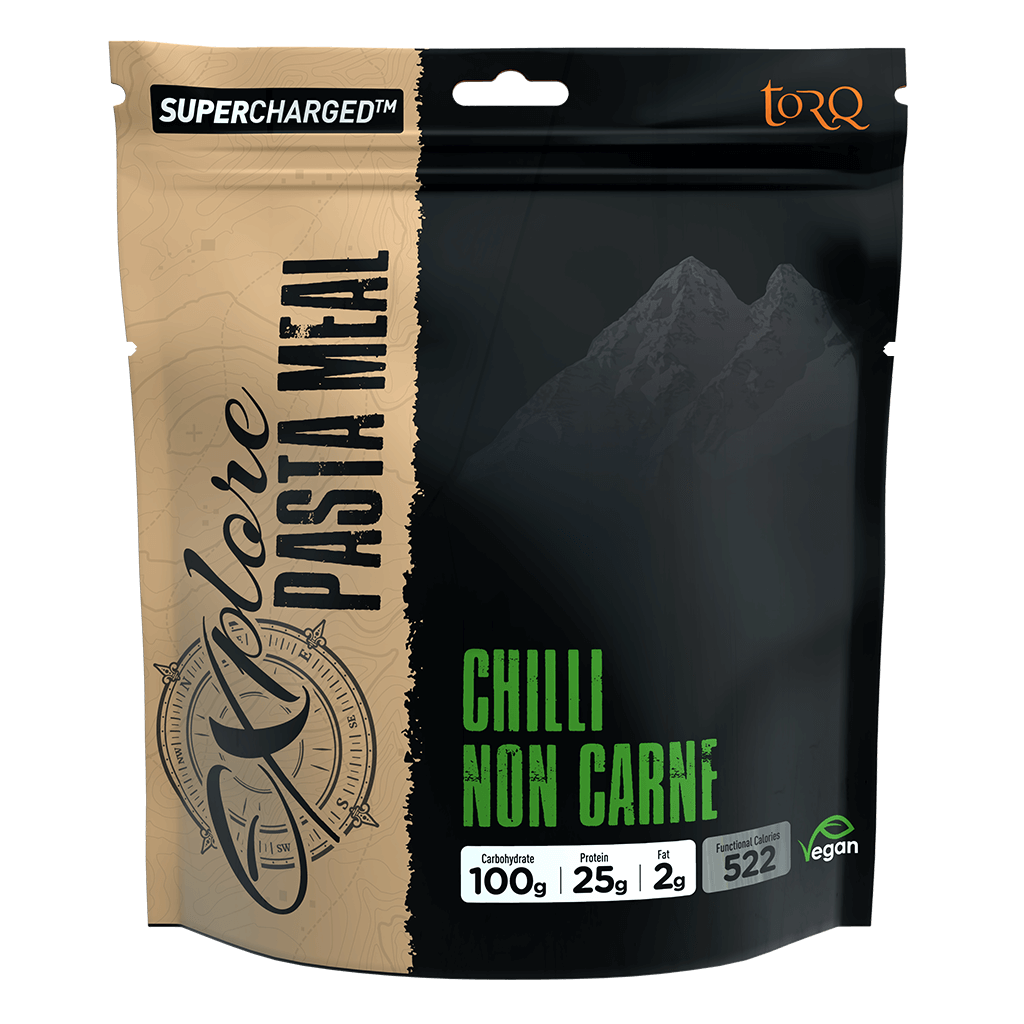 A stand-up pouch of Torq Supercharged Pasta Meal in Chilli Non Carne flavor. The packaging features a split design with a beige/tan textured left side and a black right side showing a mountain graphic, with green text.